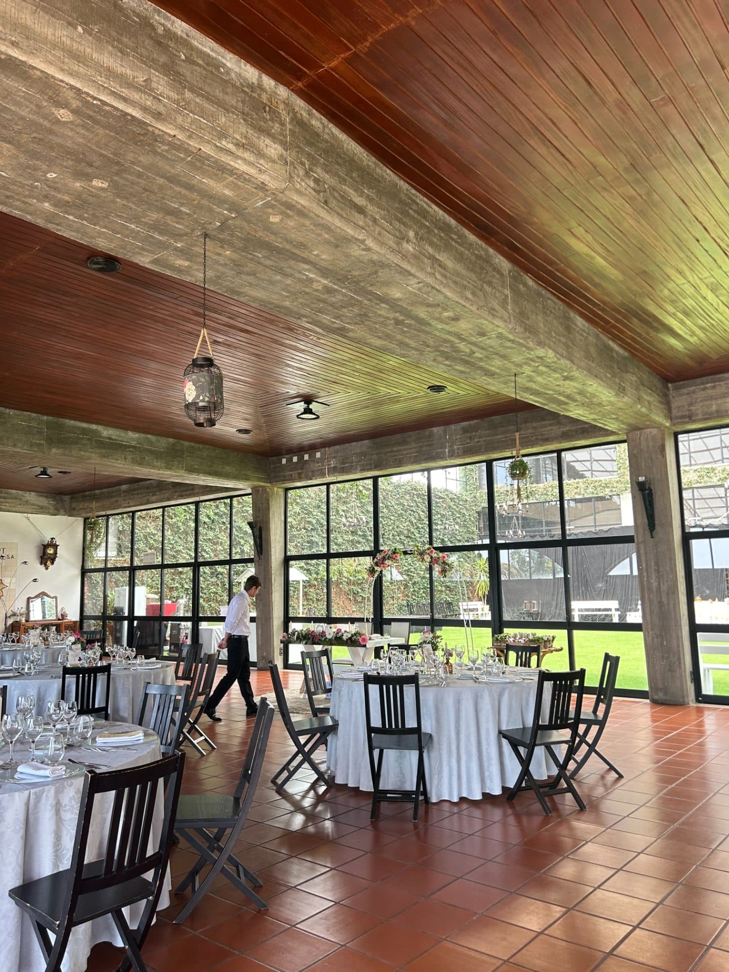Sala de torneios em madeira com mesas de bilhar e jogadores